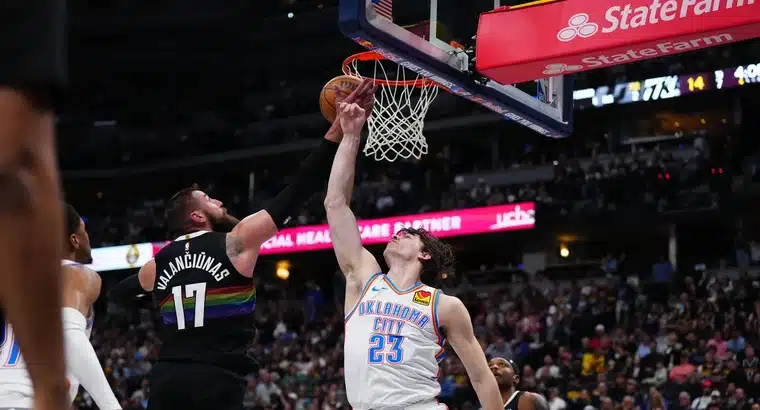 Jonas Valančiūnas #17 of the Denver Nuggets fights for the ball at the rim against an Oklahoma City Thunder player