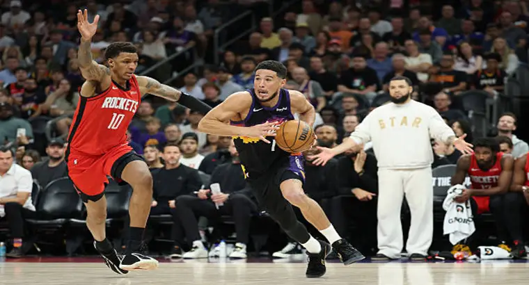 Devin Booker driving to the basket against Houston Rockets defender during NBA game April 7 2026