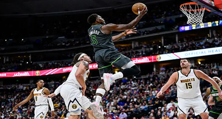  Minnesota Timberwolves guard Anthony Edwards (No. 5) attacks the rim while Nikola Jokic (No. 15) and Denver Nuggets defenders look on at Ball Arena