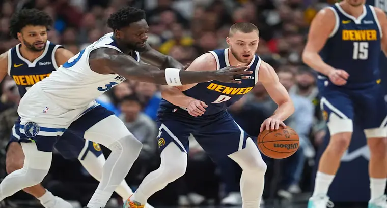 Denver Nuggets guard Christian Braun handling the ball while Minnesota Timberwolves forward Julius Randle defends during the 2026 NBA Playoffs at Ball Arena in Denver