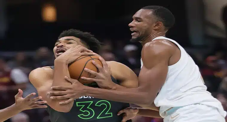 Evan Mobley of the Cleveland Cavaliers defending Karl-Anthony Towns in an NBA game