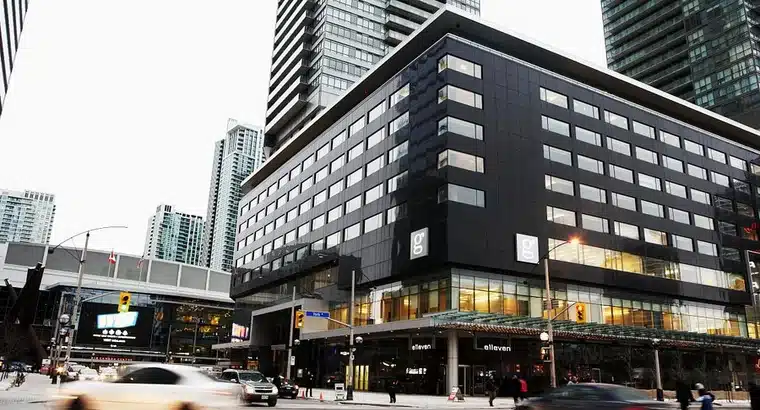 Modern downtown Toronto hotel exterior near Scotiabank Arena, showing the building at a city intersection with high-rise towers in the background