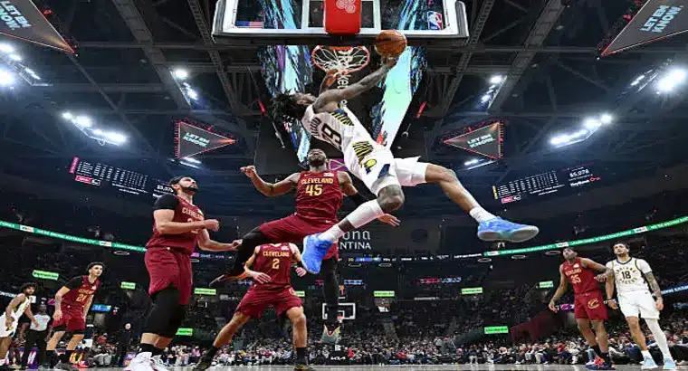 
Indiana Pacers player dunks over Cleveland Cavaliers guard Donovan Mitchell number 45 during a regular season NBA game at Rocket Mortgage FieldHouse