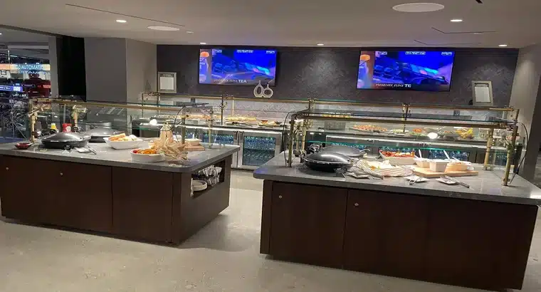 Mortgage Matchup Center suite club buffet area with food stations and live TV screens showing Phoenix Suns game