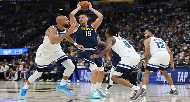 Denver Nuggets center Nikola Jokic (No. 15) holds the ball in the post as Minnesota Timberwolves defenders close in during Game 5 of the 2026 NBA Western Conference First Round on April 27, 2026