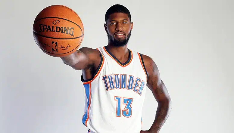 Oklahoma City Thunder player number 13 in white home jersey holding a Spalding basketball during NBA media day photo shoot