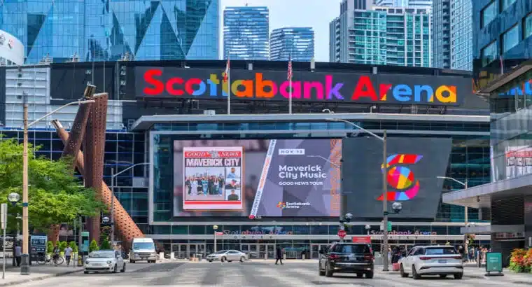 Scotiabank Arena exterior in downtown Toronto showing the large illuminated arena sign and LED digital billboard advertising a live event